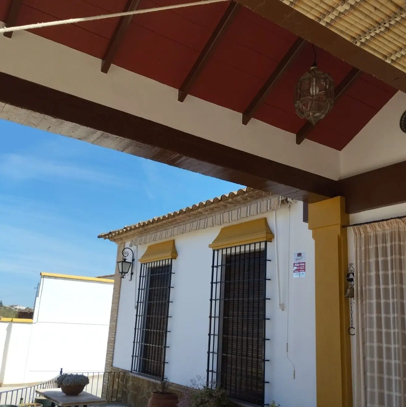 Pintura de fachada en blanco y ocre con vigas de madera en Aguilar de la Frontera