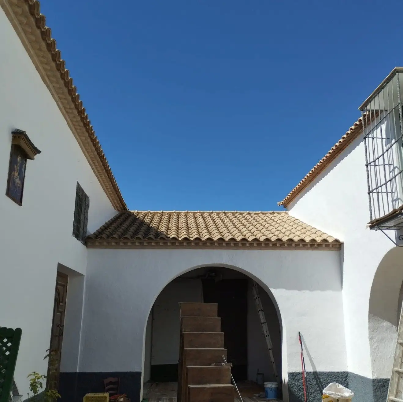 Trabajos de pintura en fachada blanca con arcos y tejado de teja en Aguilar de la Frontera