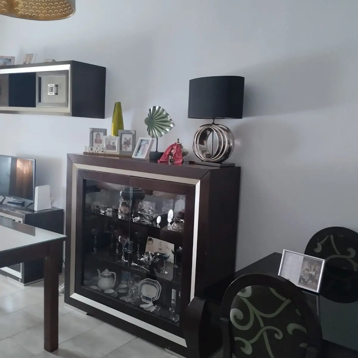 Trabajo de pintura en salón con paredes blancas y mobiliario de madera oscura en Aguilar de la Frontera