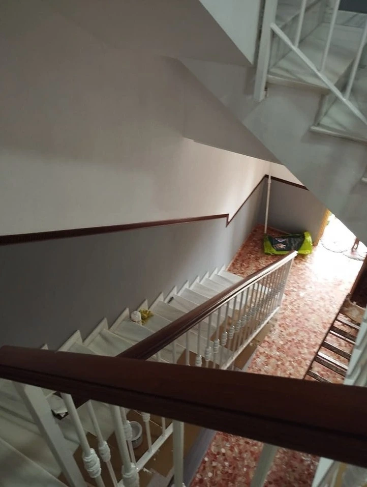 Trabajo de pintura en escalera con paredes bitono en gris y blanco en Aguilar de la Frontera